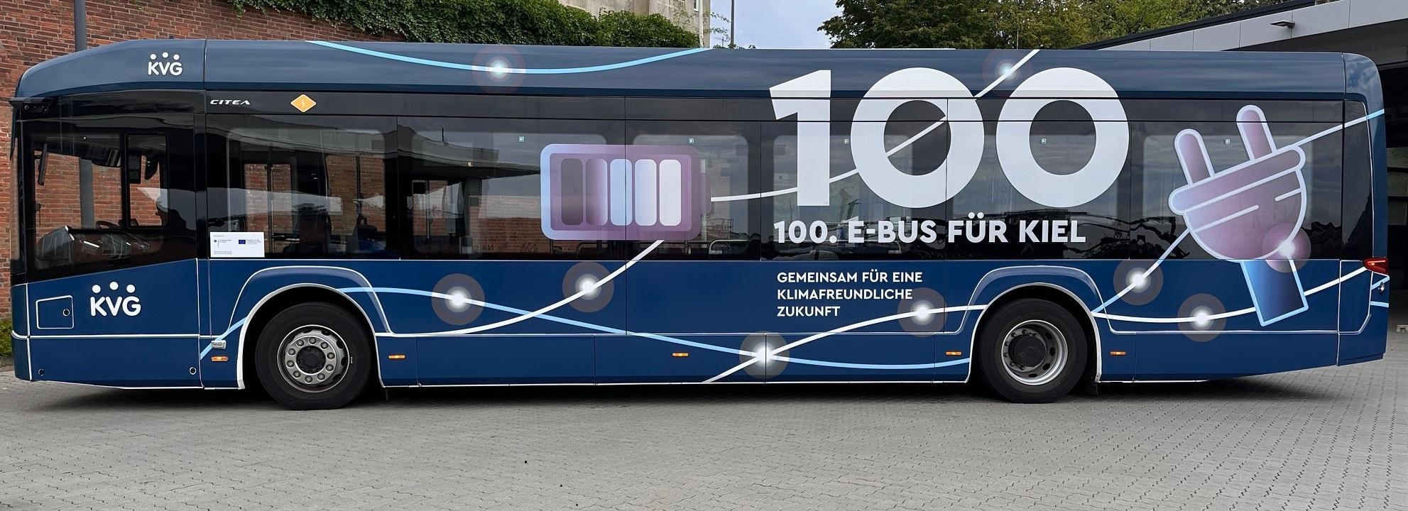 Folierter Elektrobus mit großer 100 auf der Seite.